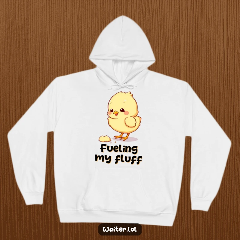 Funny hoodie with a fluffy chick character pecking at a crumb, radiating warmth and playful cuteness.